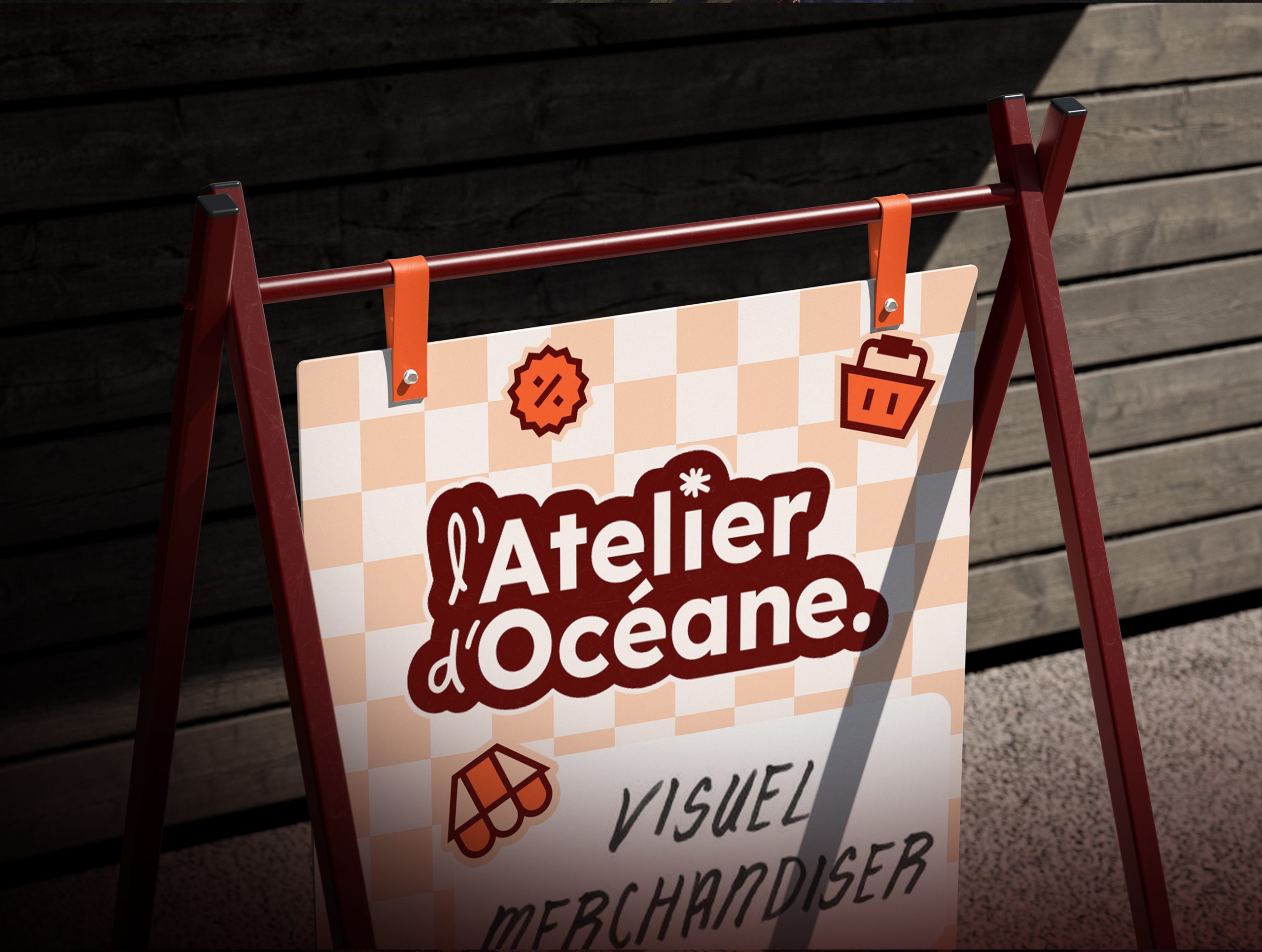 Panneau chevalet bordeaux sur un trottoir, avec une affiche à carreaux beige et le texte « l’Atelier d’Océane ». Petites icônes, pourcentage, panier, auvent en haut de l’affiche.